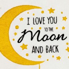 Close-up van geborduurde tekst 'I Love You to the Moon and Back' met een gele maan en sterren.